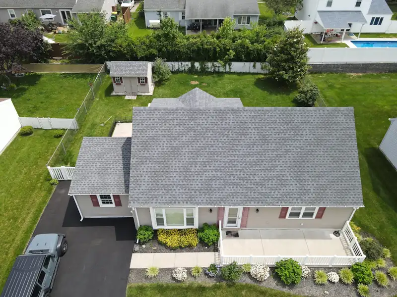 Aerial view of a suburban home with a grey roof