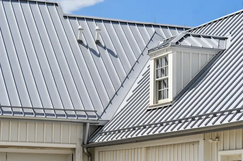 Grey metal roof with white siding and a dormer
